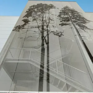 Architectural facade with large-scale tree decoration on metal mesh panels, Pure Metal Tech® by Dreamet